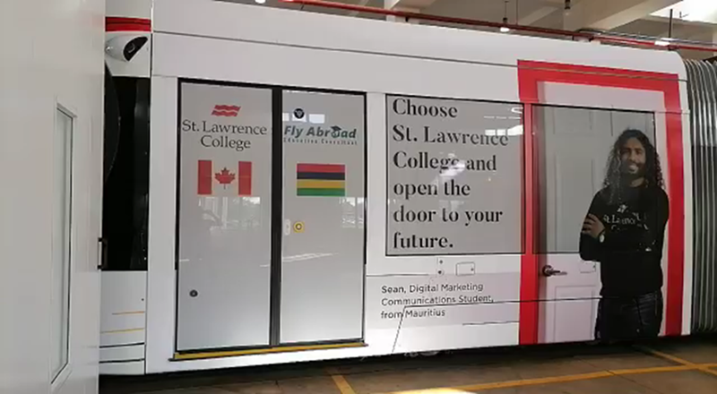 An SLC advertisement featuring Sean Ozeer appears on the side of a metro train in Mauritius.